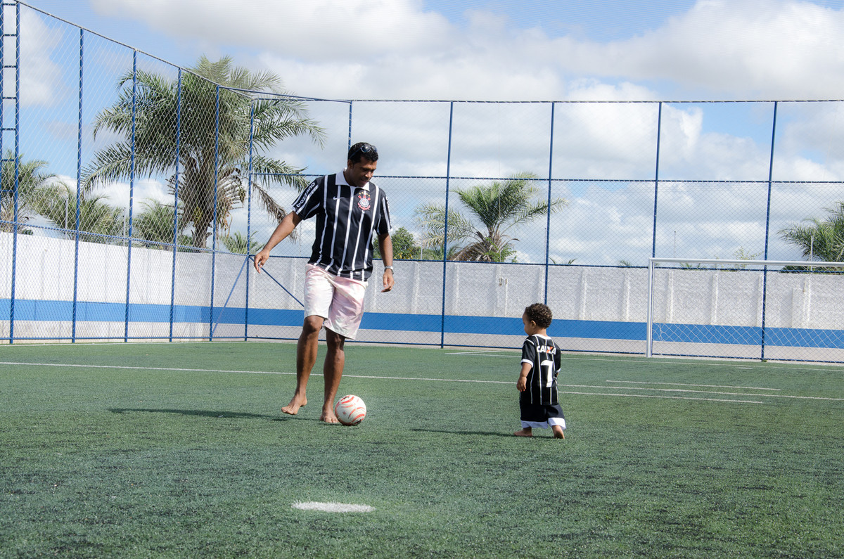 Pai e filho batendo uma bola