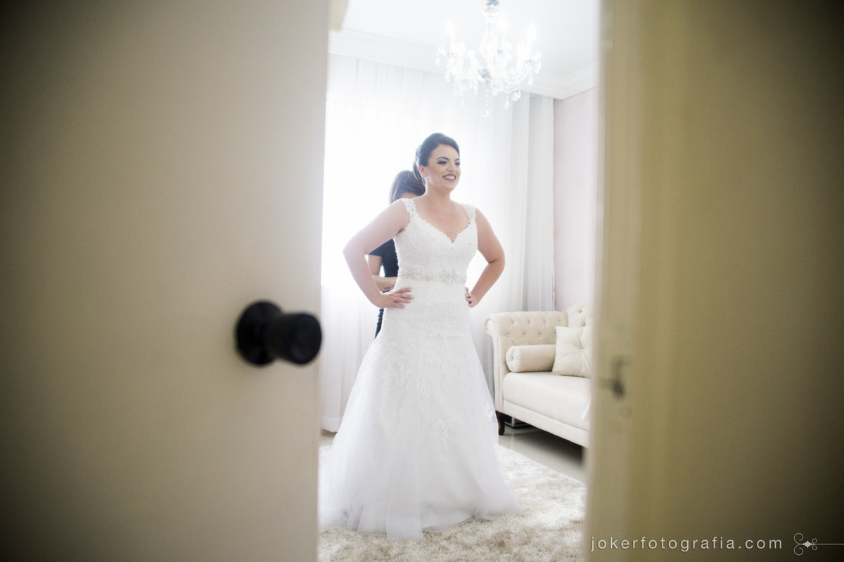 fotógrafo capta momento da maquiadora ajudando a noiva a fechar o vestido
