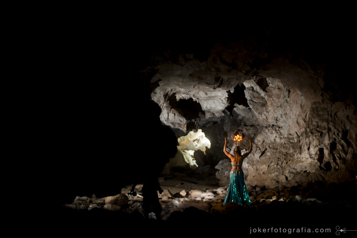 inspiração para dança do ventre, dançarina usando candelabro faz fotos dentro de uma caverna