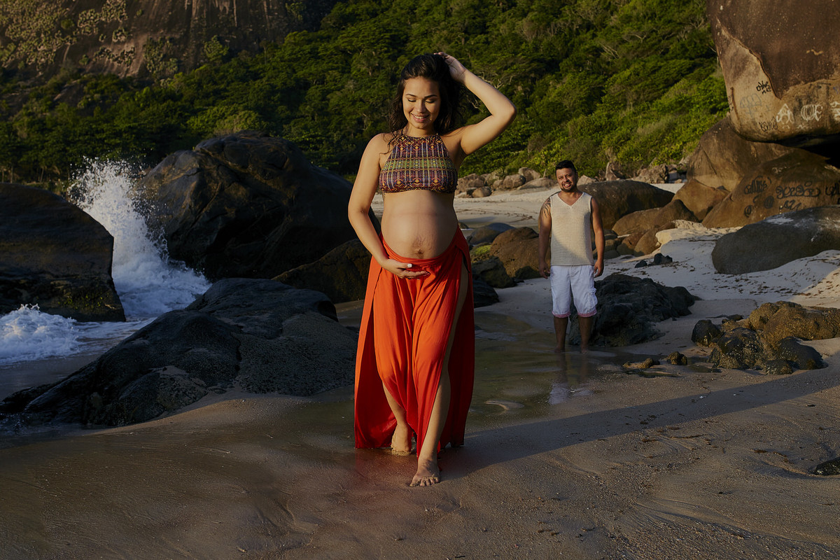 fotografia de gestante correndo na praia no nascer do sol