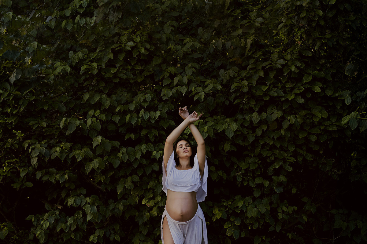 fotografia diferente de gestante bailarina dançando gravida na folhagem