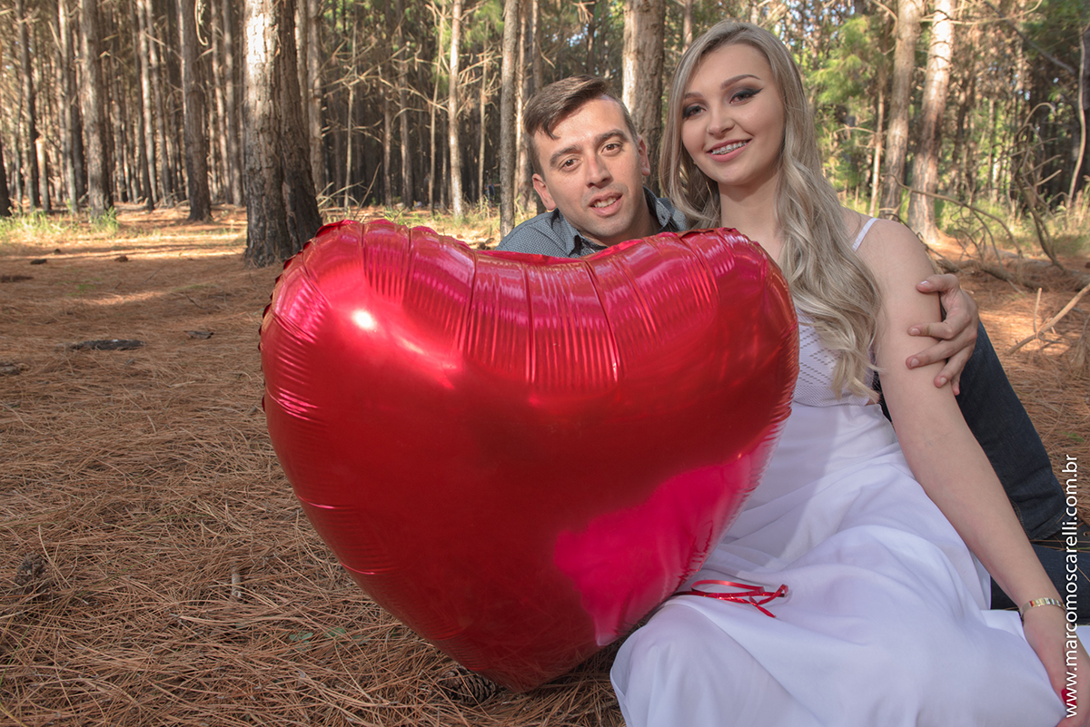 Casal de noivos posando para foto com balão em forma de coração durante ensaio pré wedding no las acacias em Pelotas.Foto por Marco Moscarelli Fotografo