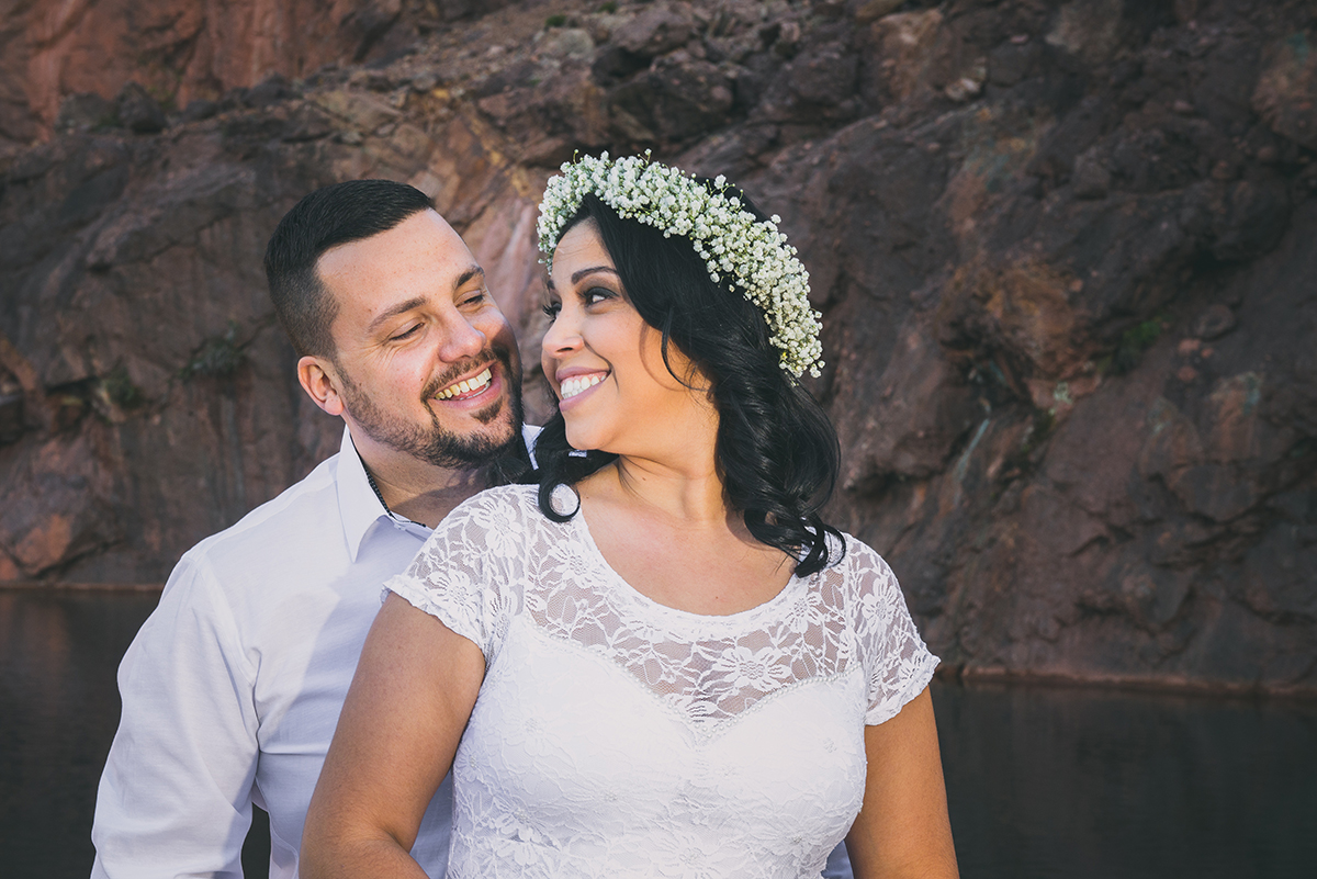 Noiva e noivo trocando olhares e sorrisos felizes durante o seu ensaio de casal pré wedding.