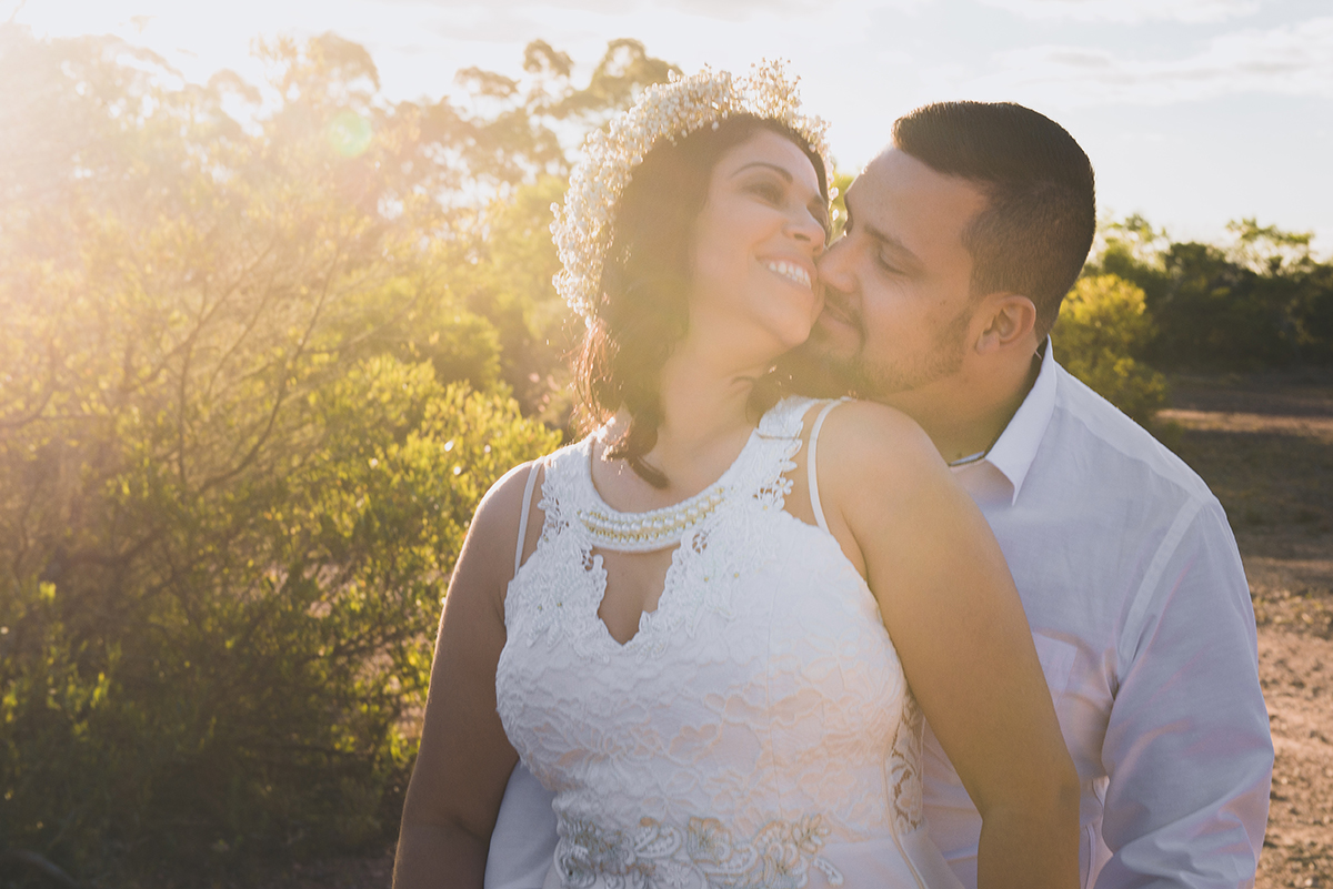 Linda foto contra a luz com a luz do sol entrando com tons amarelados do casal de noivos em seu ensaio pré wedding realizado antes do casamento nas minas do camaquã