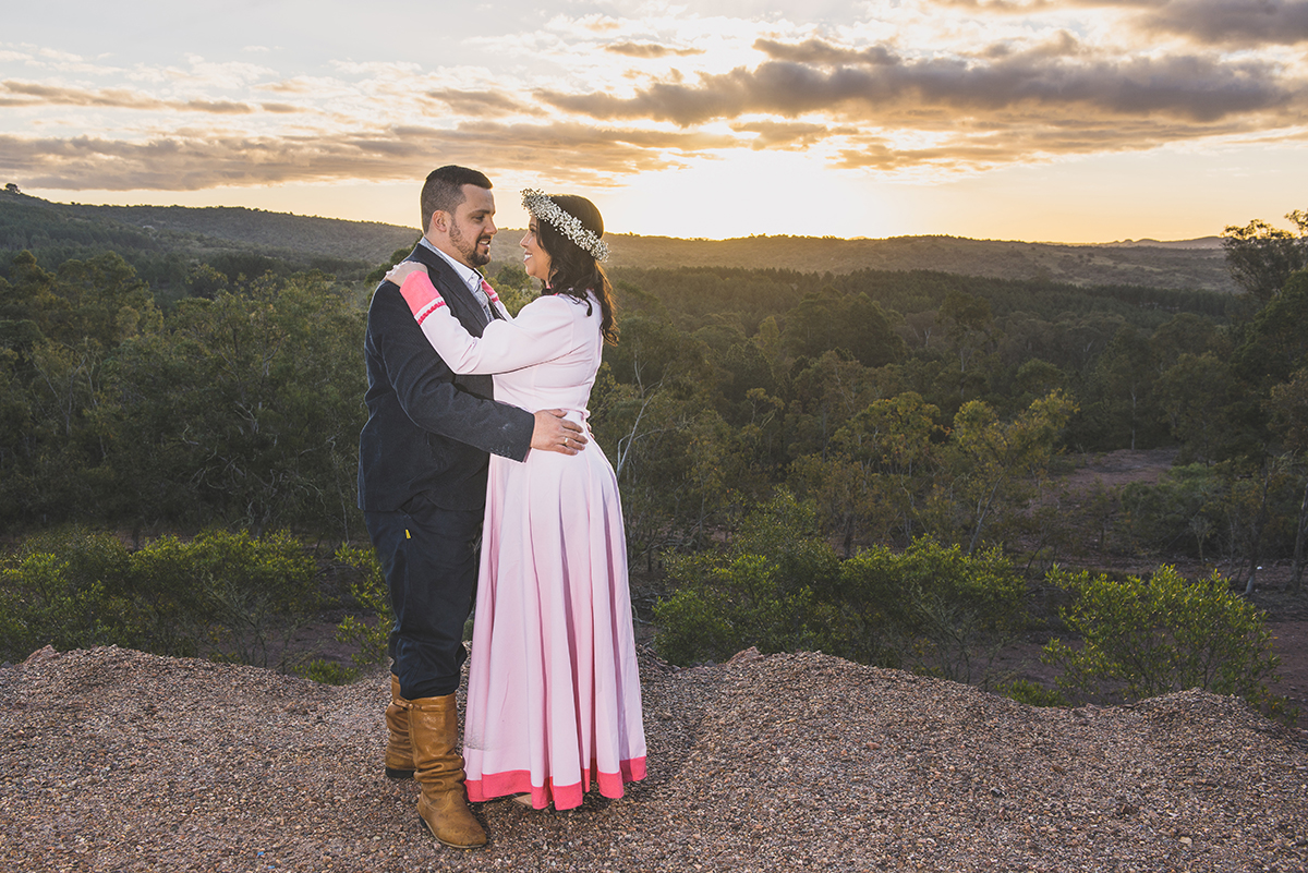Casal de noivos trocando olhares com um lindo pordo sol ao fundo compondo a paisagem deste pre wedding feito antes do casamento nas minas do camaquã