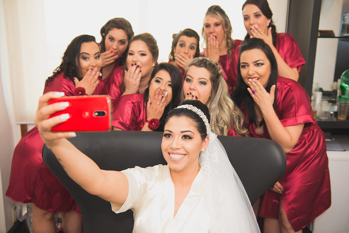 Foto bem humorada da noiva e das madrinhas do casamento posando para selfie.