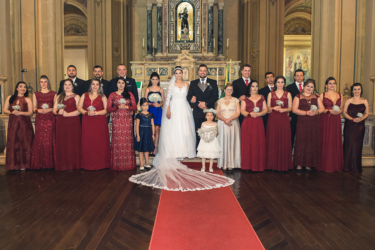 Fotografia oficial com padrinhos e familiares no altar ao final do casamento.