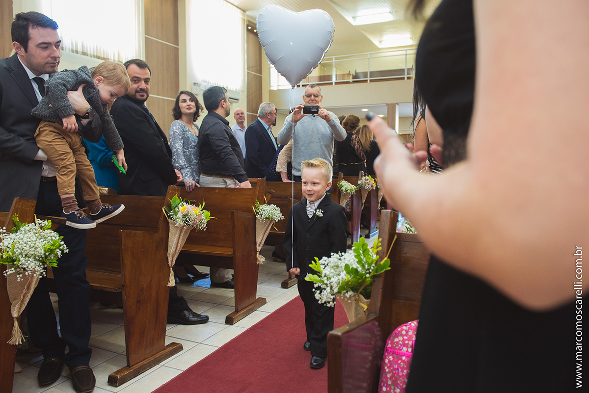 Entrada do pagem carregando um balão em forma de coração ma cerimonia de casamento. Foto por Marco Moscarelli