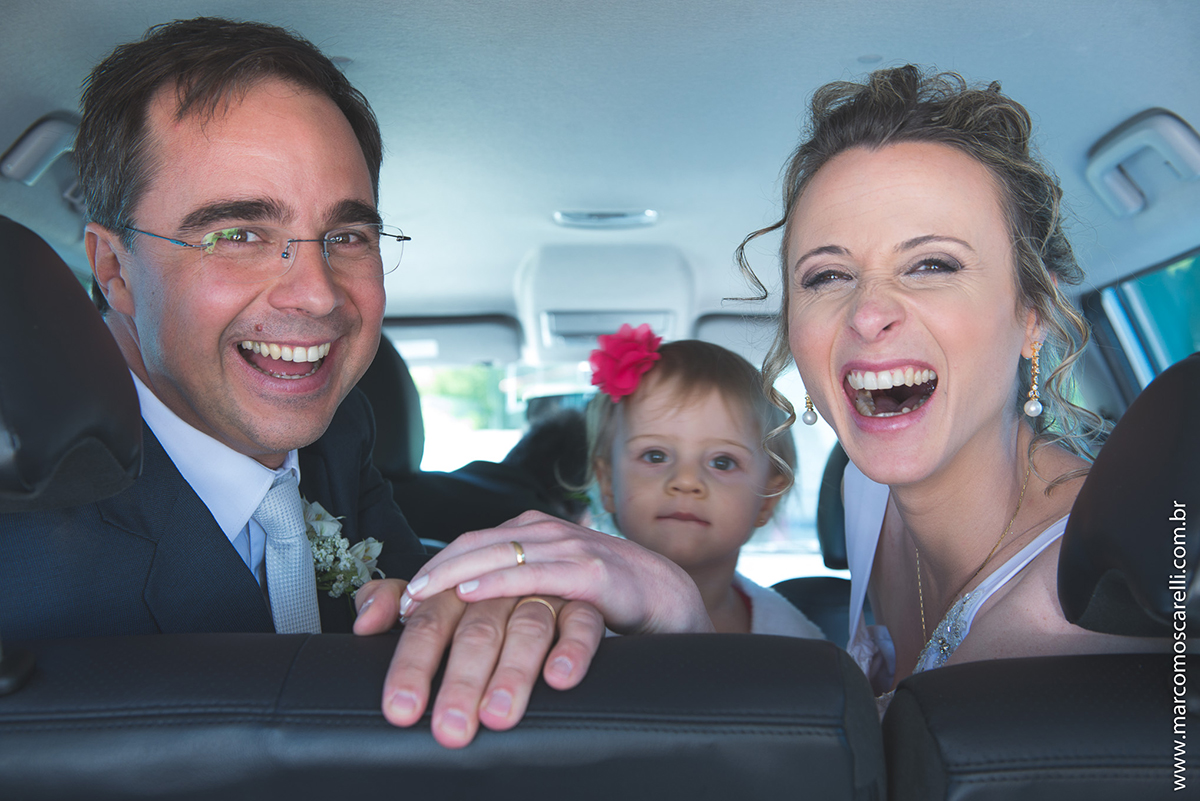 Foto descontraida dos noivos dentro do carro após a cerimônia de casamento. Foto por Marco Moscarelli