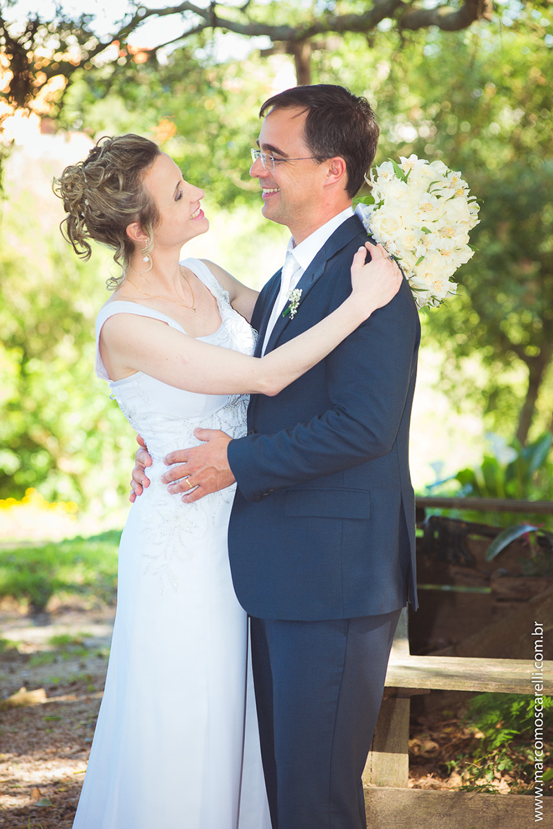 Noivos lindos e sorridentes em seu ensaioi após o casamento, posando ao pé de uma linda figueira. Foto por Marco Moscarell