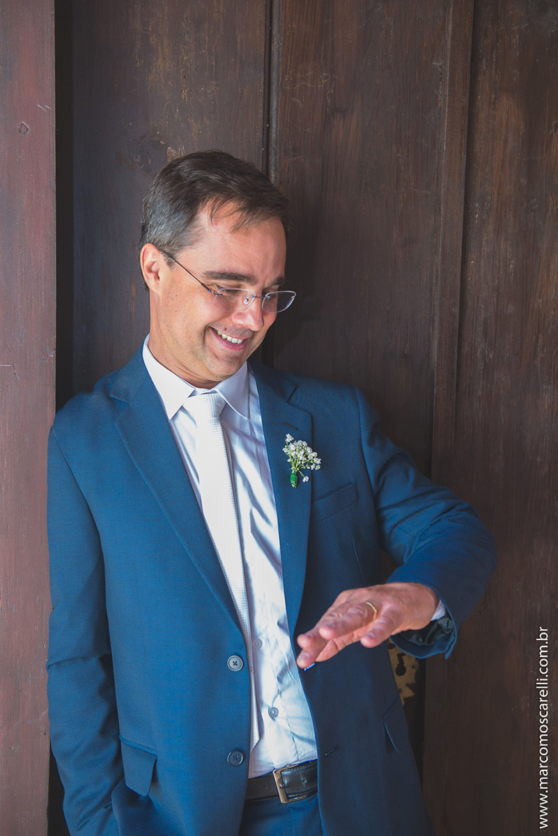 Noivo posando para foto admirando a aliança de casamento no ensaio pós casamento. Foto por Marco Moscarelli