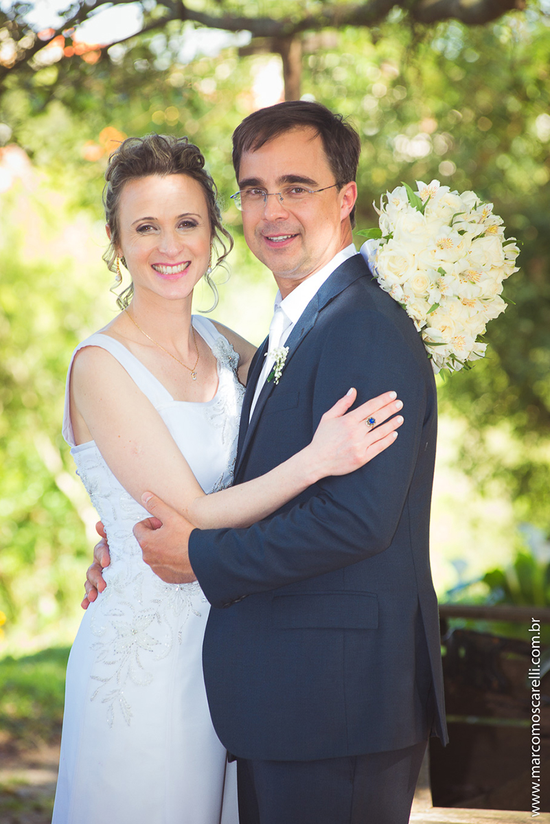 Noivos lindos e sorridentes em seu ensaioi após o casamento, posando ao pé de uma linda figueira. Foto por Marco Moscarell