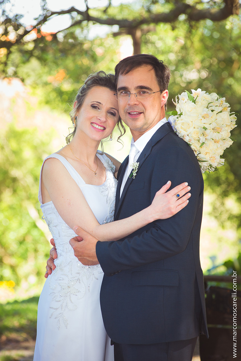 Noivos lindos e sorridentes em seu ensaioi após o casamento, posando ao pé de uma linda figueira. Foto por Marco Moscarell