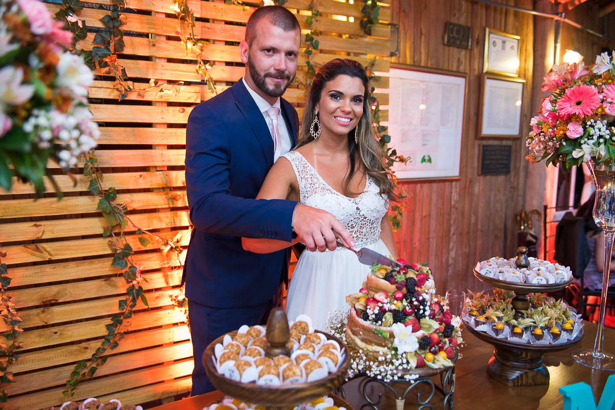 Noivos cortando o bolo do casamento. Foto Marco Moscarelli. Casamento Clube Caça e Pesca Pelotas