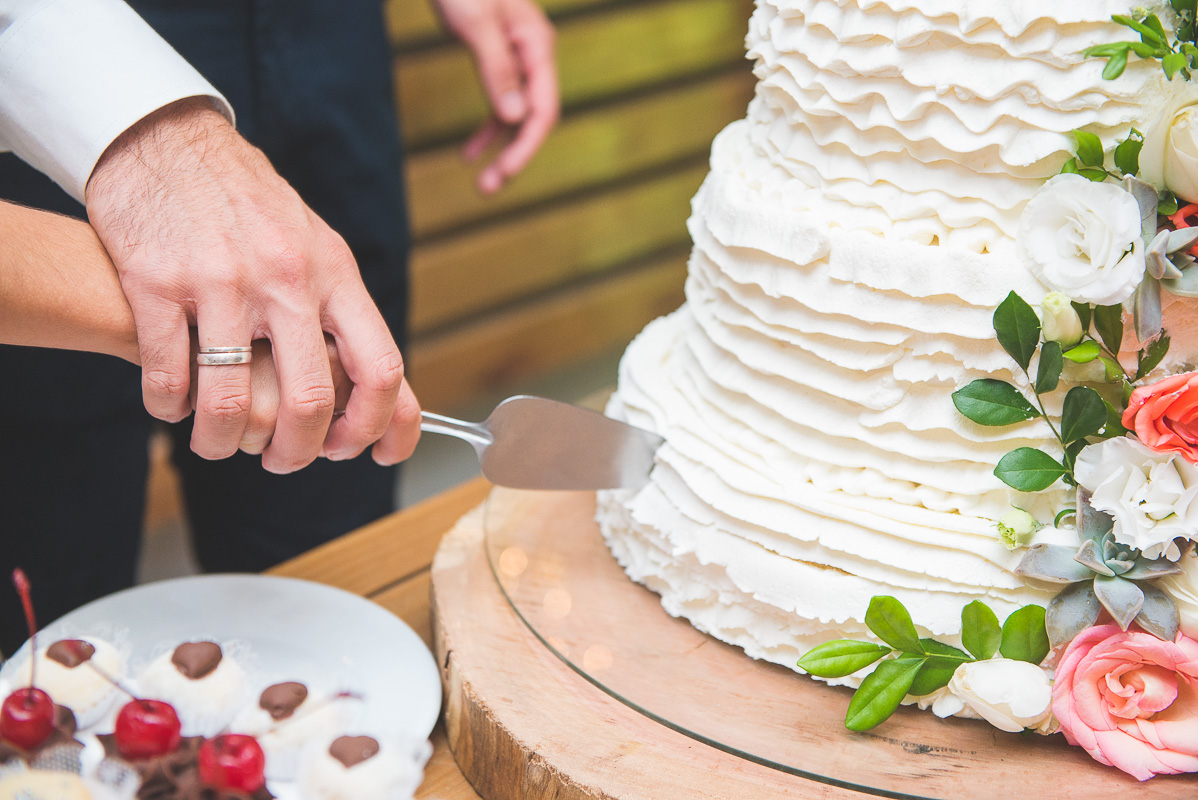 Casal de noivos corantando o bolo de casamento após a cerimônia de casamento. Foto por Marco Moscarelli Fotografo