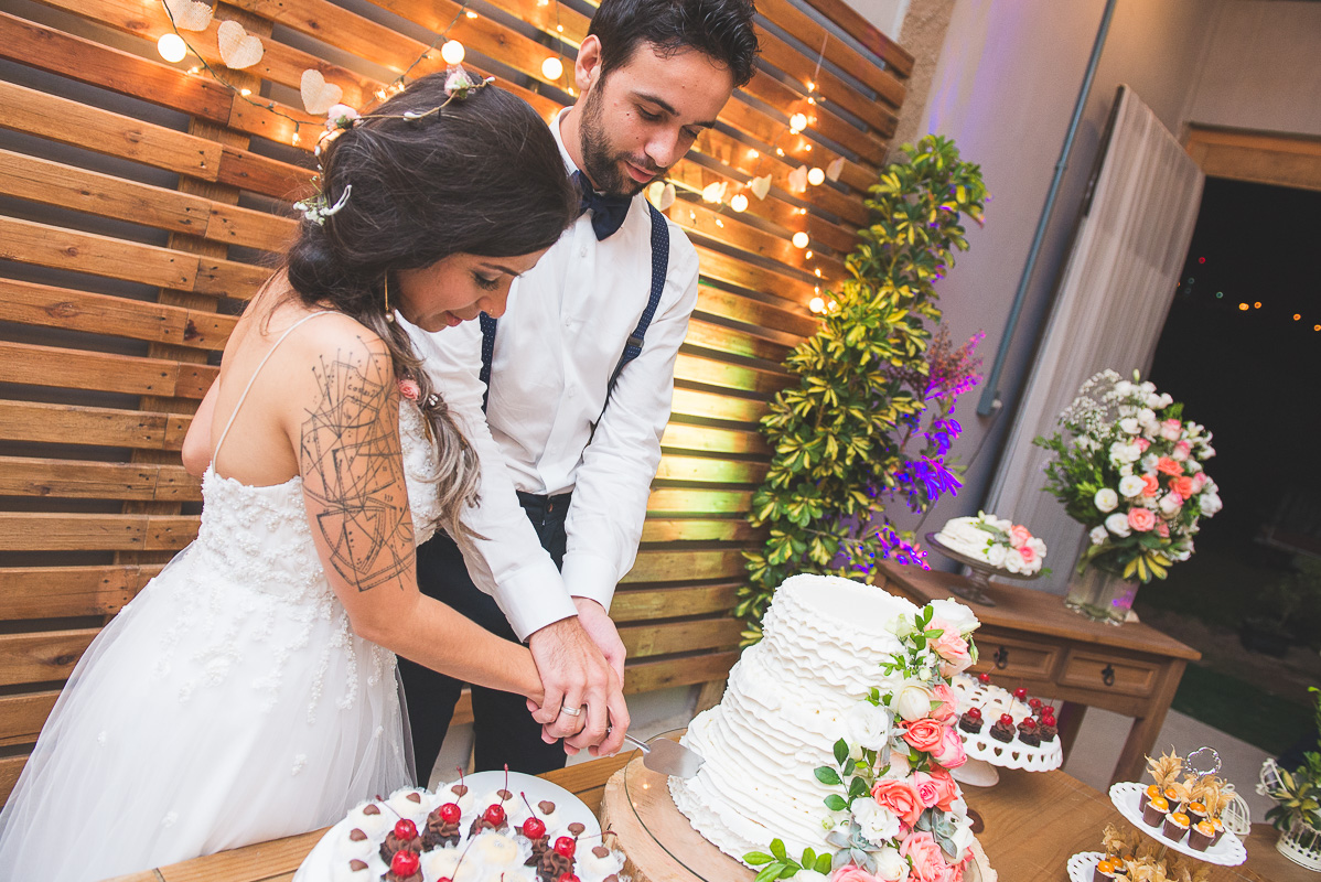 Casal de noivos corantando o bolo de casamento após a cerimônia de casamento. Foto por Marco Moscarelli Fotografo