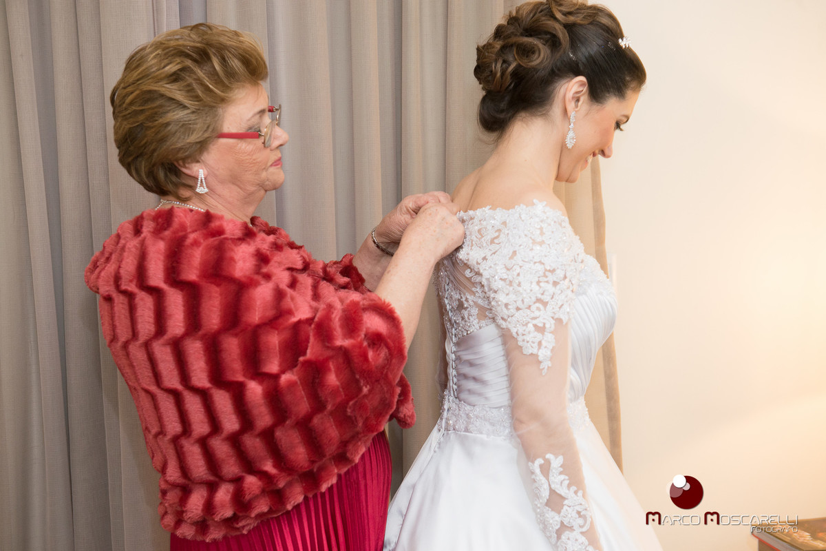 Mãe da noiva abotoando o vestido de noiva momentos antes do casamento. Foto POr Marco Moscarelli