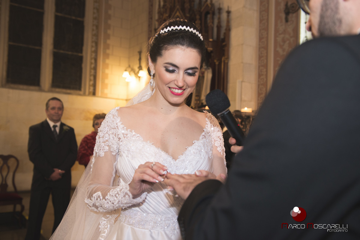 Noiva colocando a aliança no dedo do noivo durante a celebração do casamento. Foto por Marco Moscarelli