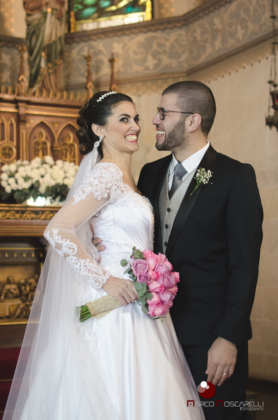 Foto dos noivos no altar após o casamento.