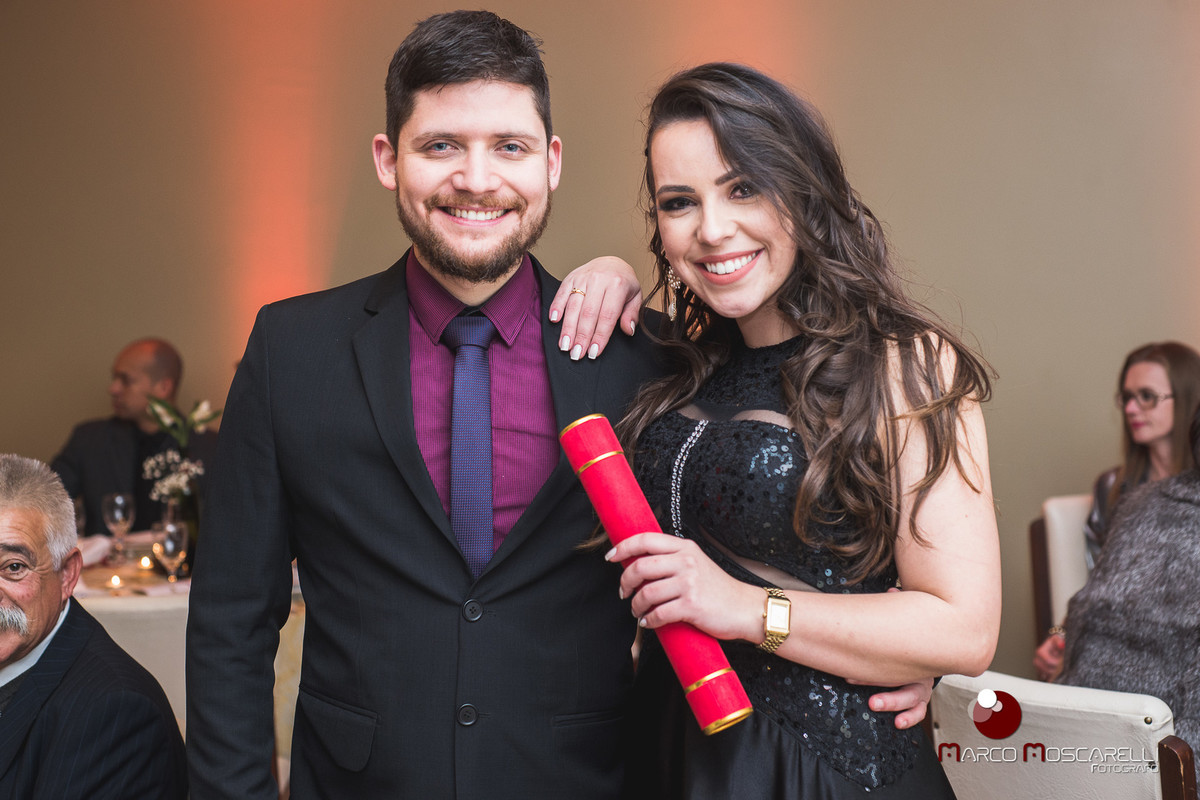 Formanda em direito posando com seu canudo de formatura