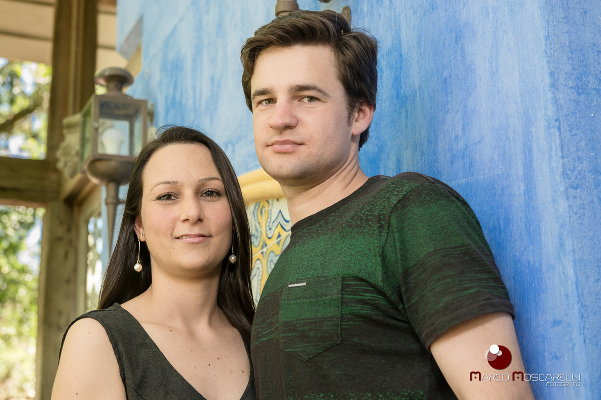 Casal de noivos posando para fotos do ensaio pré - weding em uma parede azul na charqueada santa rita.