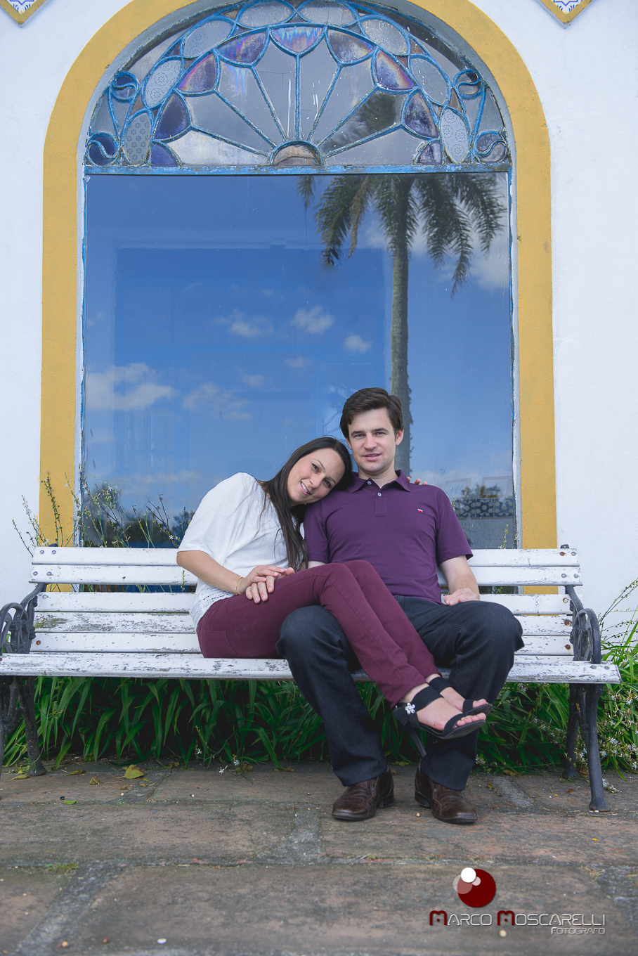 Casa de noivos sentados em banco na frente de uma linda janela em ensio pré wedding. Foto Marco Moscarelli
