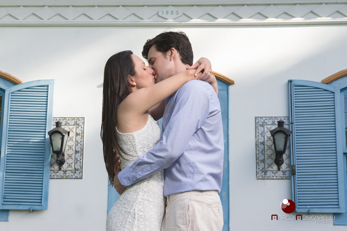 Noivos em ensaio pré wedding, posando com portas e janelas azuis de casa antiga. fotos de casamento por Marco Moscarelli