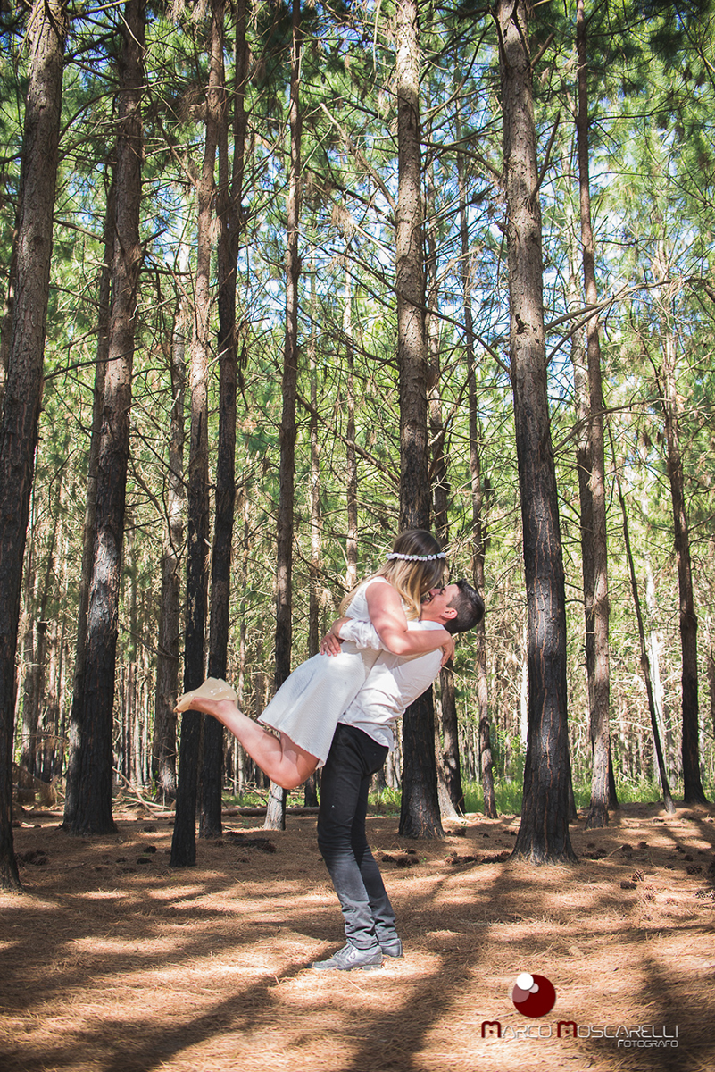 Ensaio pré-wedding, noivo segura noiva no colo como no dia do casamento. Foto em las acacias Pelotas em um lindo bosque de acacias.