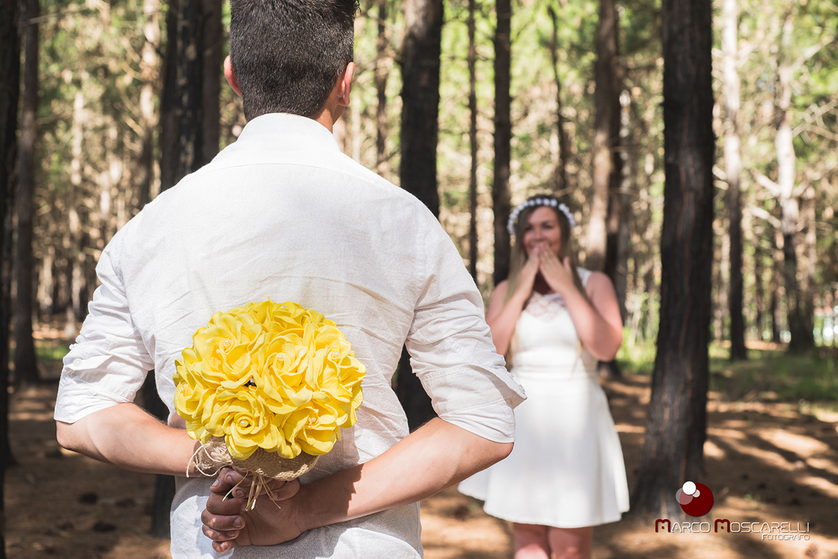 Noivo escondendo o buque da noiva durante ensaio pré-wedding. O buquê será o mesmo usado no casamento. Foto feia em Las acacias em Pelotas. Foto por Marco Moscarelli.