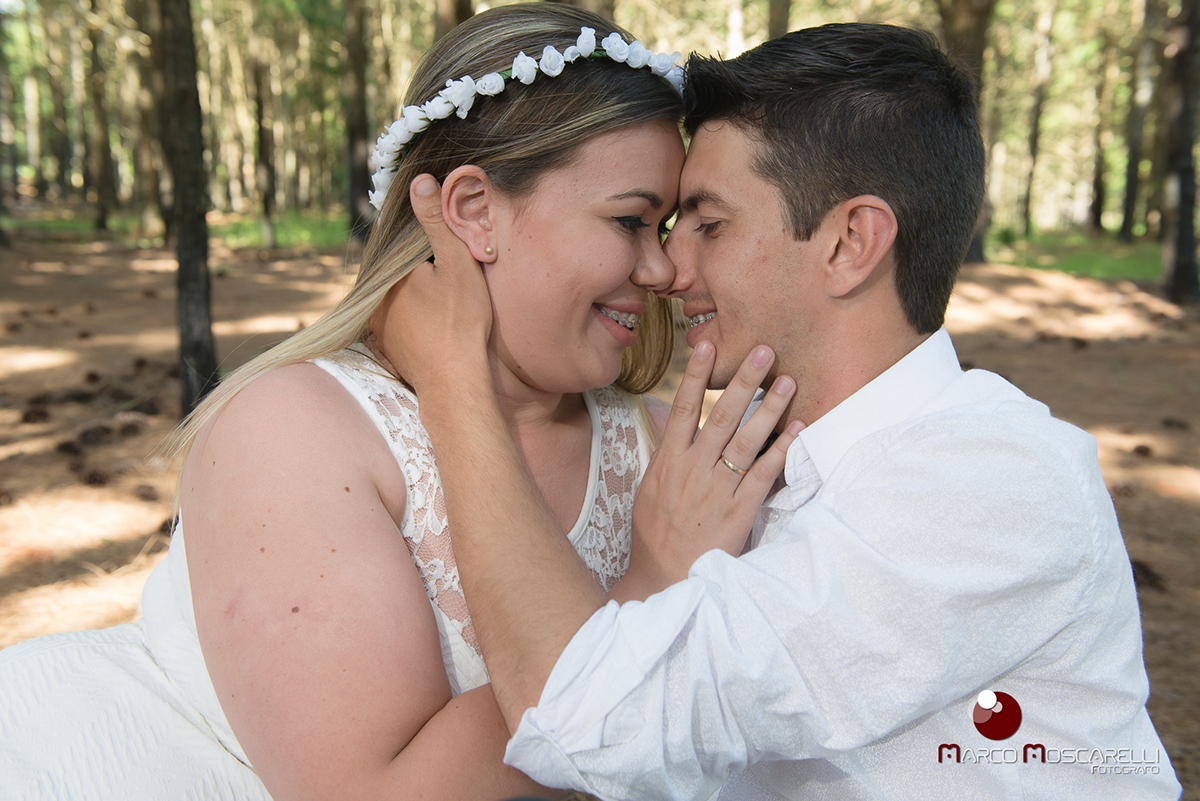 Noivo e noiva de rosto colado com lindo bosque de acacias ao fundo em ensaio pré-wedding. Foto por Marco Moscarelli