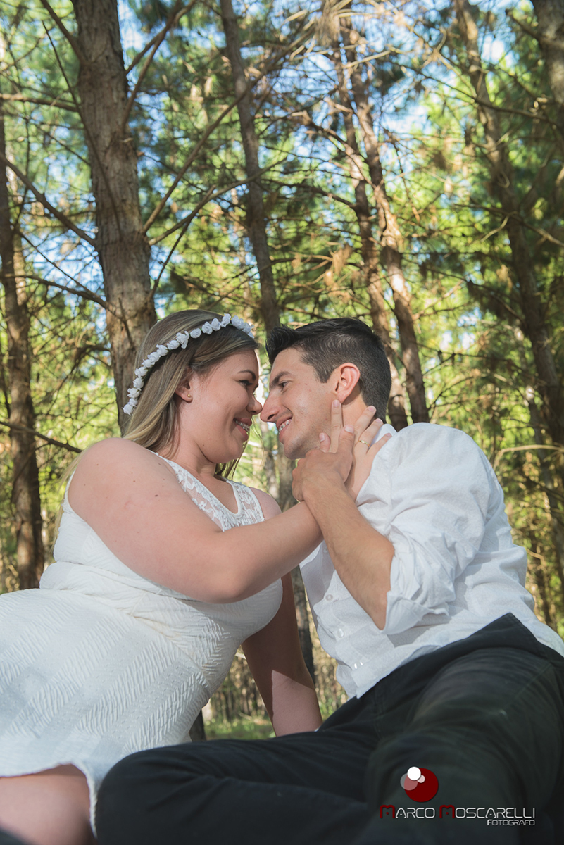 Noivo e noiva de rosto colado com lindo bosque de acacias ao fundo em ensaio pré-wedding. Foto por Marco Moscarelli