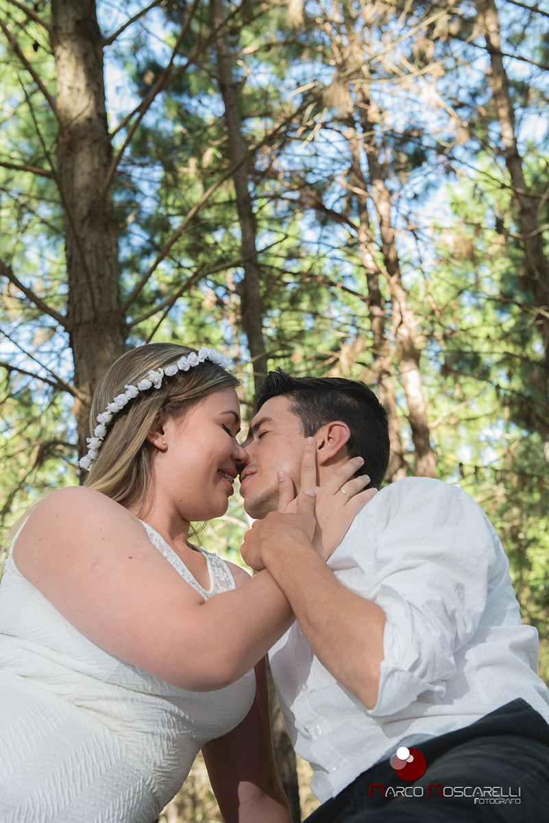 Noivo e noiva de rosto colado com lindo bosque de acacias ao fundo em ensaio pré-wedding. Foto por Marco Moscarelli