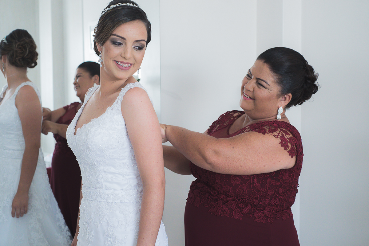Mae da noiva ajustando o vestido antes da cerimonia de casamento
