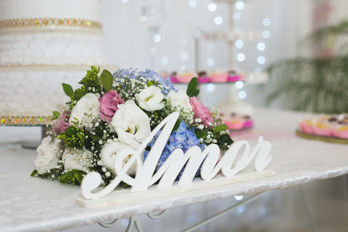 detalhe da decoração da mesa dos noivos. Amor escrito em madeira na cor branca.