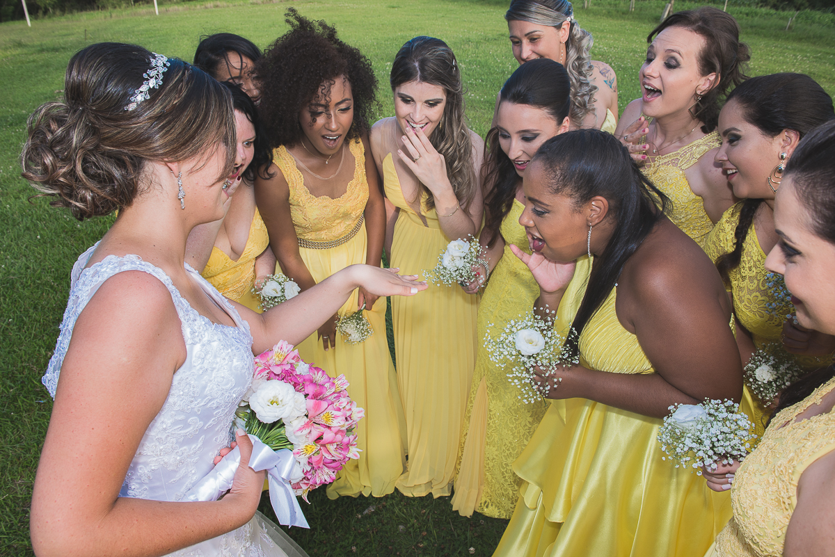 Madrinha olhando admiradas a aliança da noiva após o casamento.