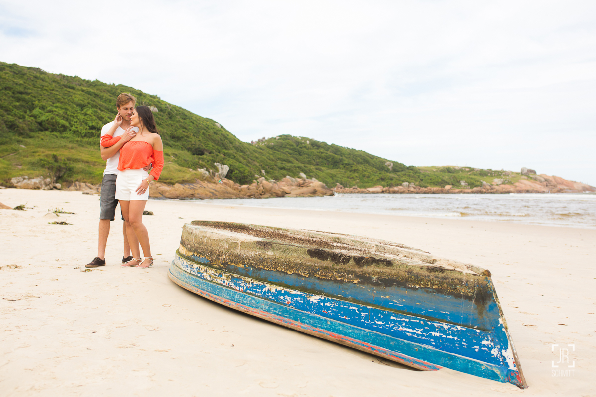 casal na praia com barco virado