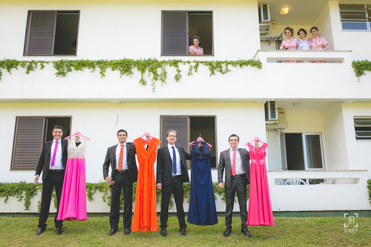 Padrinhos segurando vestidos das madrinhas, madrinhas na janela