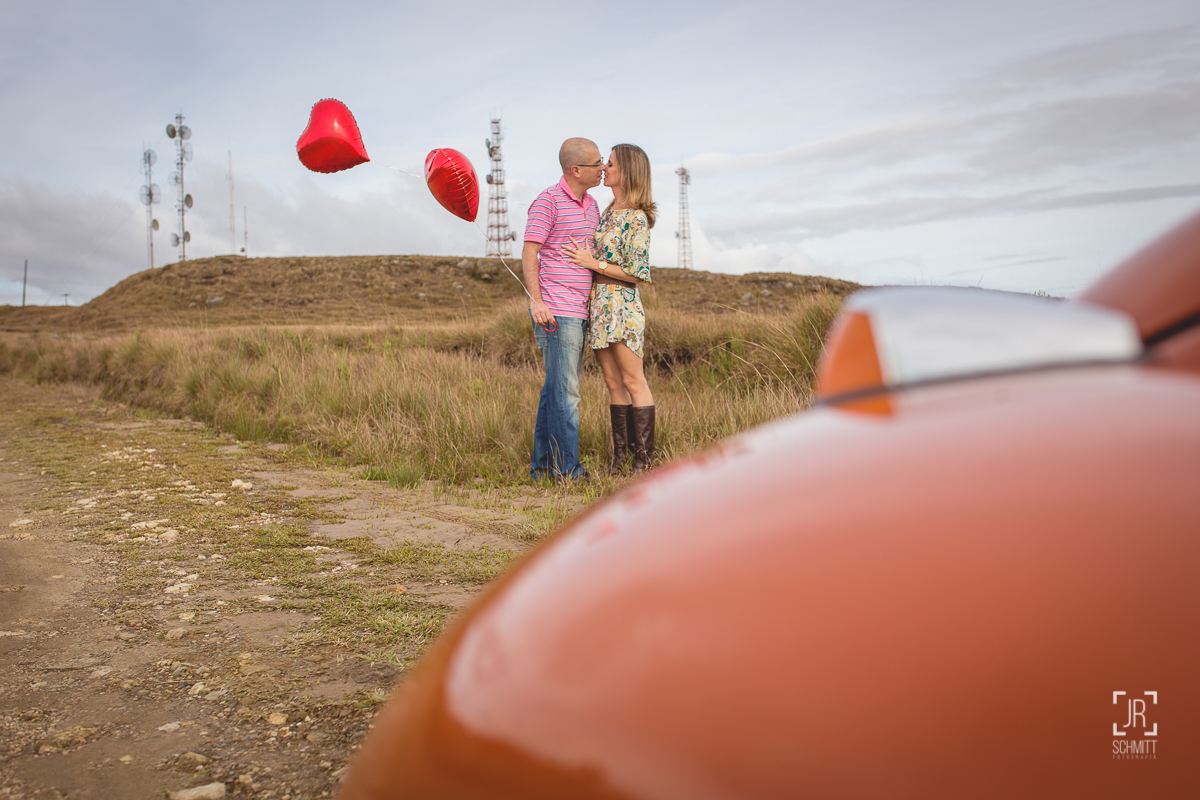 casal com balão de coração e fusca