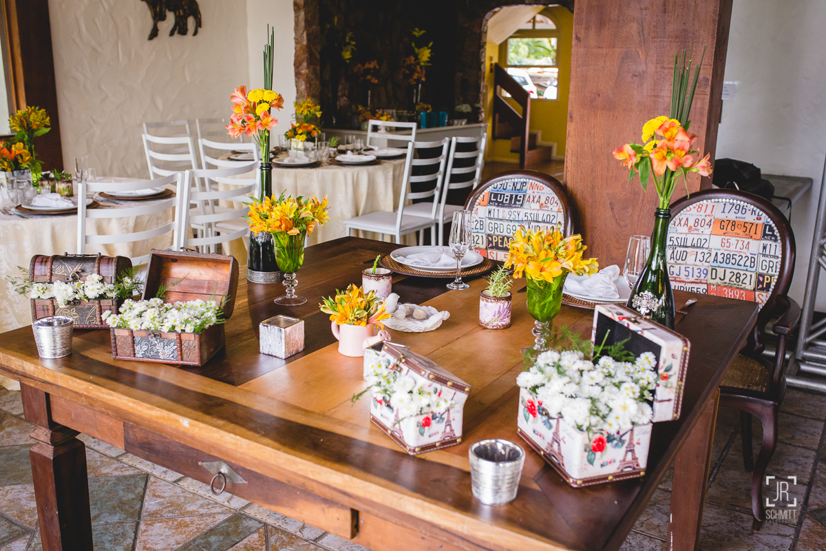 Mesa dos noivos com flores amarelas e vasos de garrafa de espumante