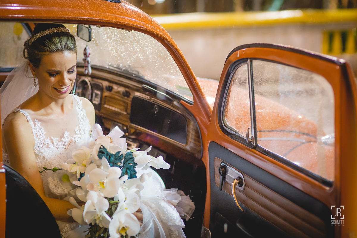noiva chegando na igreja de fusca laranja