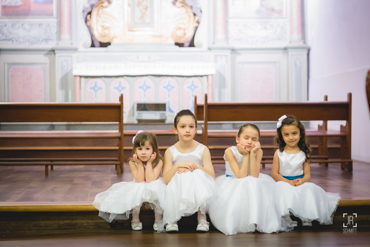 daminhas sentadas no canto da igreja observam a cerimônia