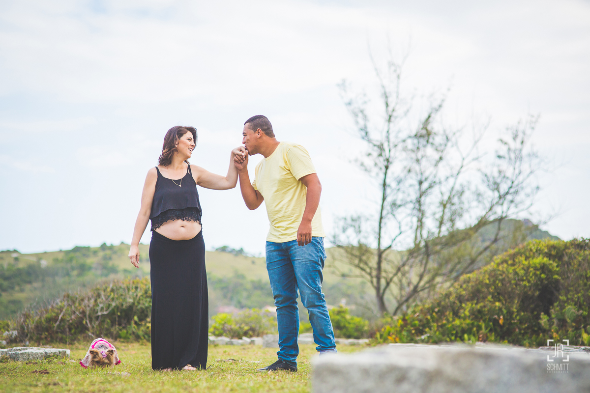 pai beijando a mão da esposa na sessão fotográfica de gestante