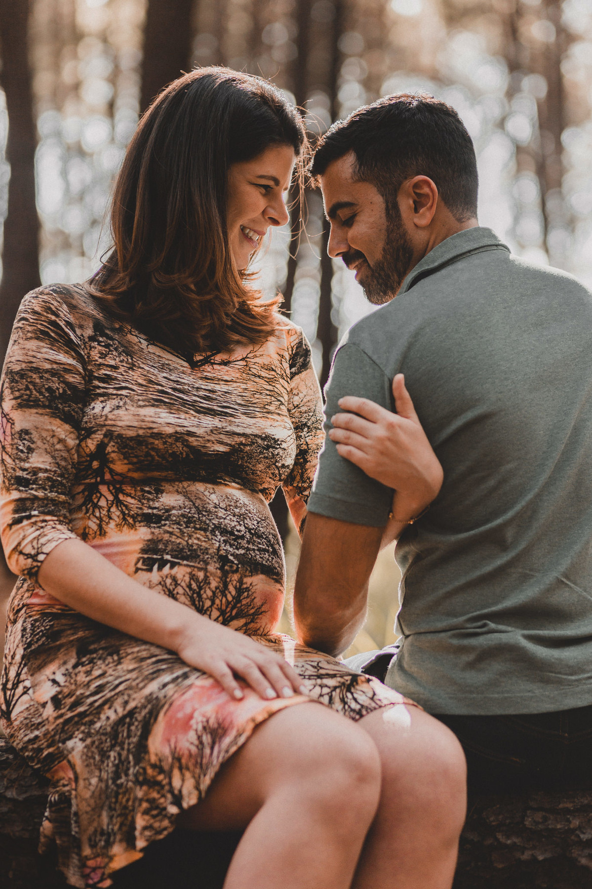 Ensaio de Gestante Ana Flávia e Guilherme. Casal abraçado sorrindo em floresta. Foto feita pelo fotógrafo Gabriel Pelaquim.