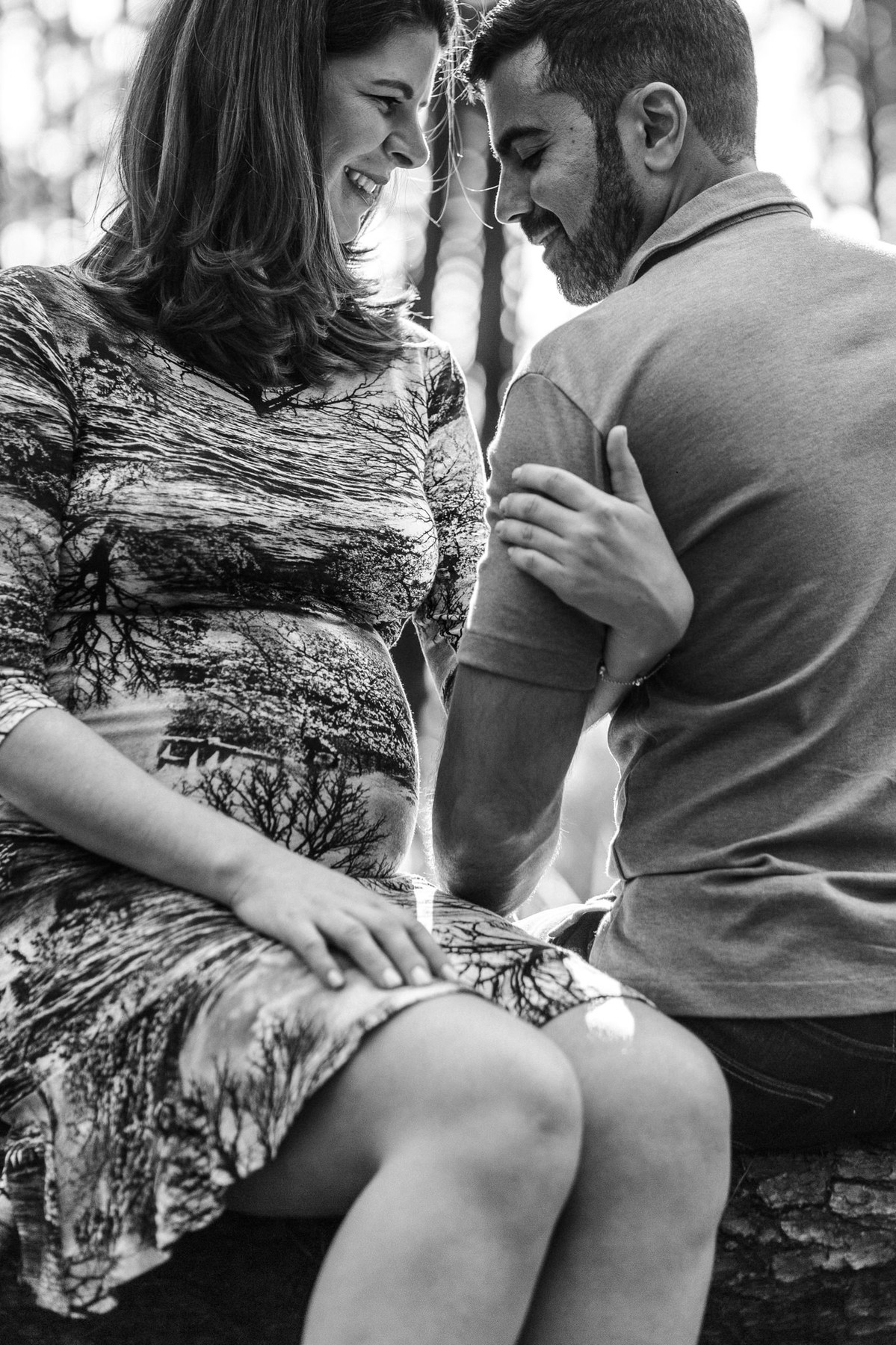 Ensaio de Gestante Ana Flávia e Guilherme. Casal abraçado sorrindo em floresta. Foto feita pelo fotógrafo Gabriel Pelaquim.