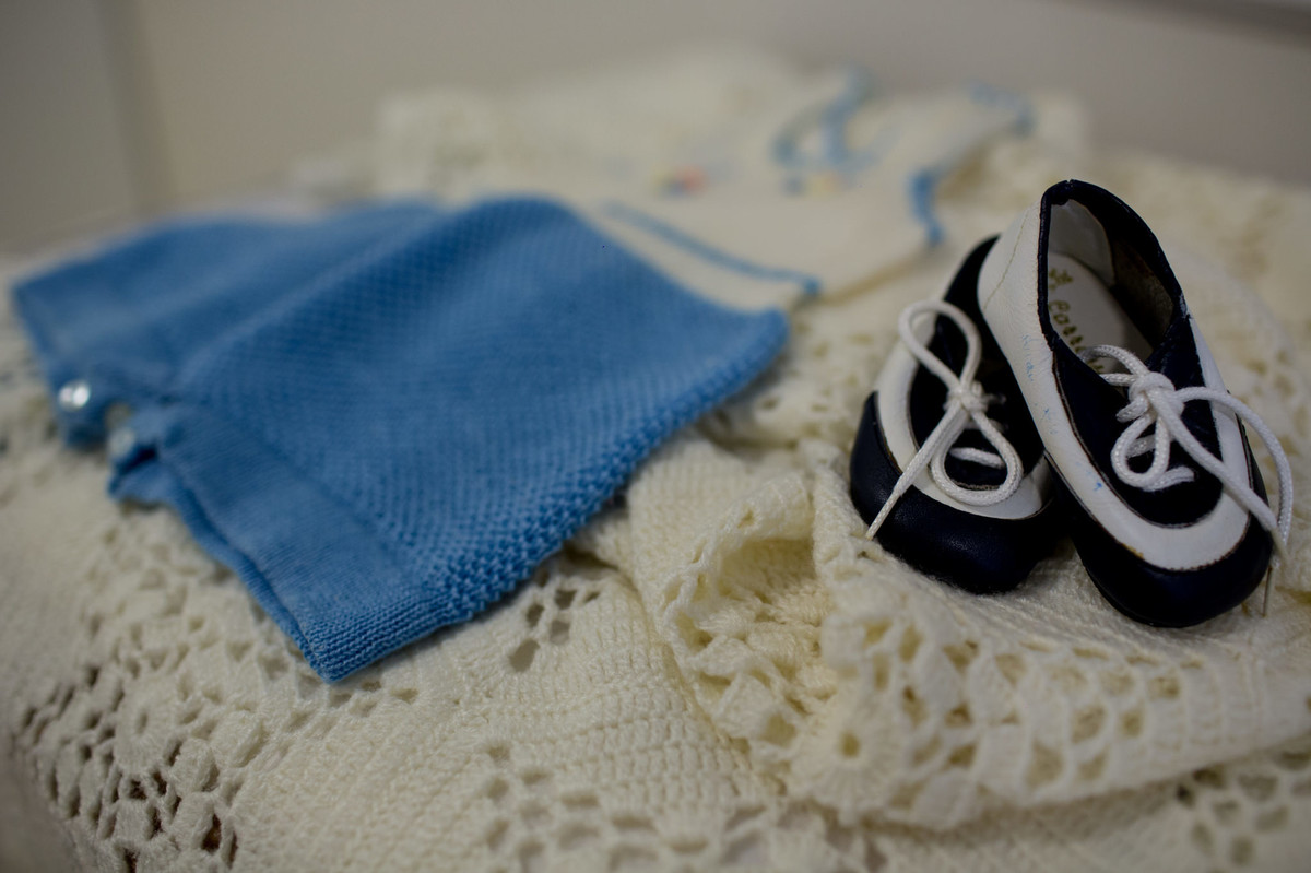Roupas e sapatos de neném. Foto pelo fotógrafo Gabriel Pelaquim.