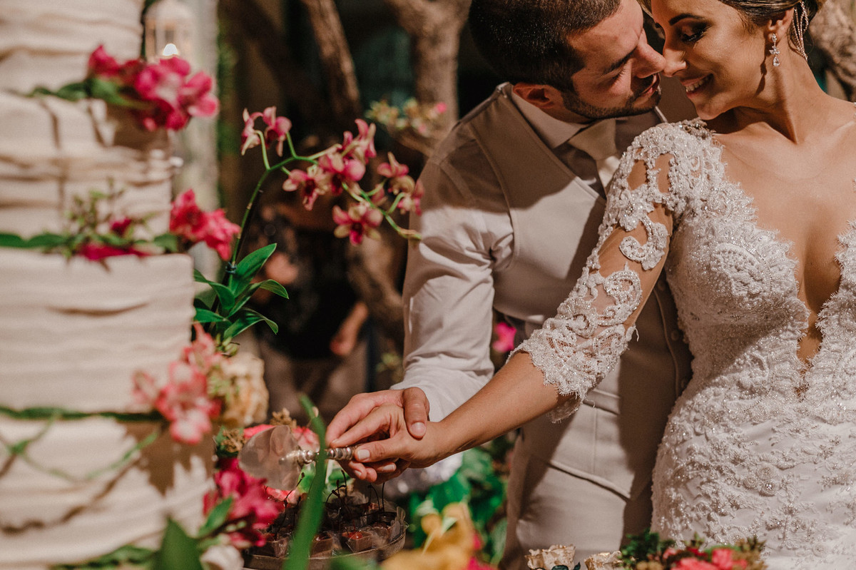 Noivos cortando o bolo no Villa Giardini. Foto pelo fotógrafo de casamento Gabriel Pelaquim.