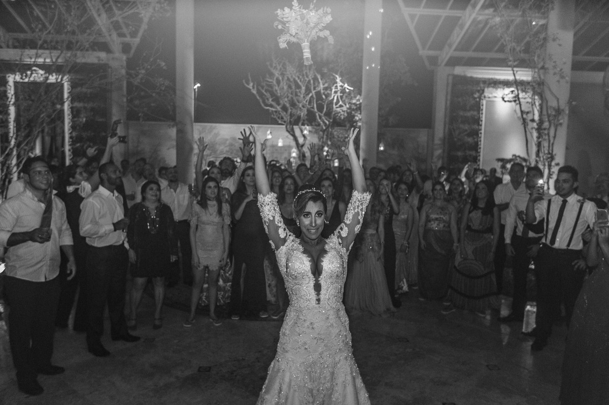 Noiva jogando o buquê na festa de casamento no Villa Giardini. Foto pelo fotógrafo de casamento Gabriel Pelaquim.