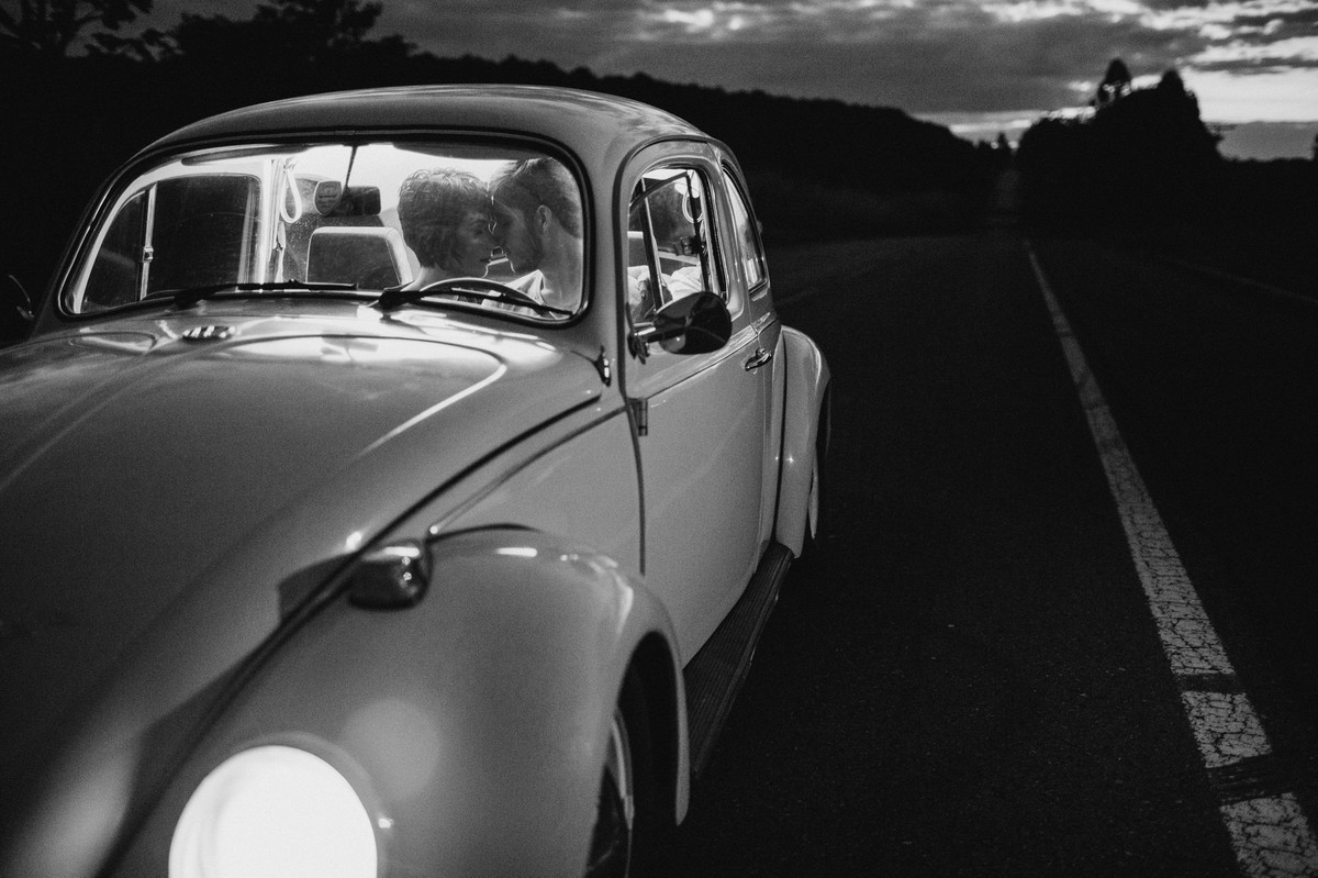 Casal se beijando dentro de fusca em estrada em Brasília. Foto feita pelo fotógrafo de casamento Gabriel Pelaquim.