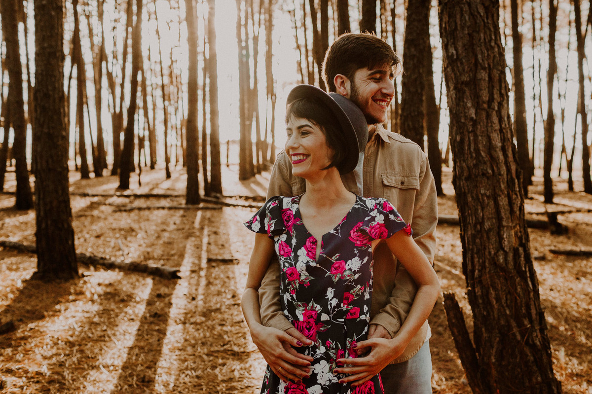 Casal abraçado sorrindo em floresta de pinheiros em Brasília. Foto feita pelo fotógrafo de casamento Gabriel Pelaquim.