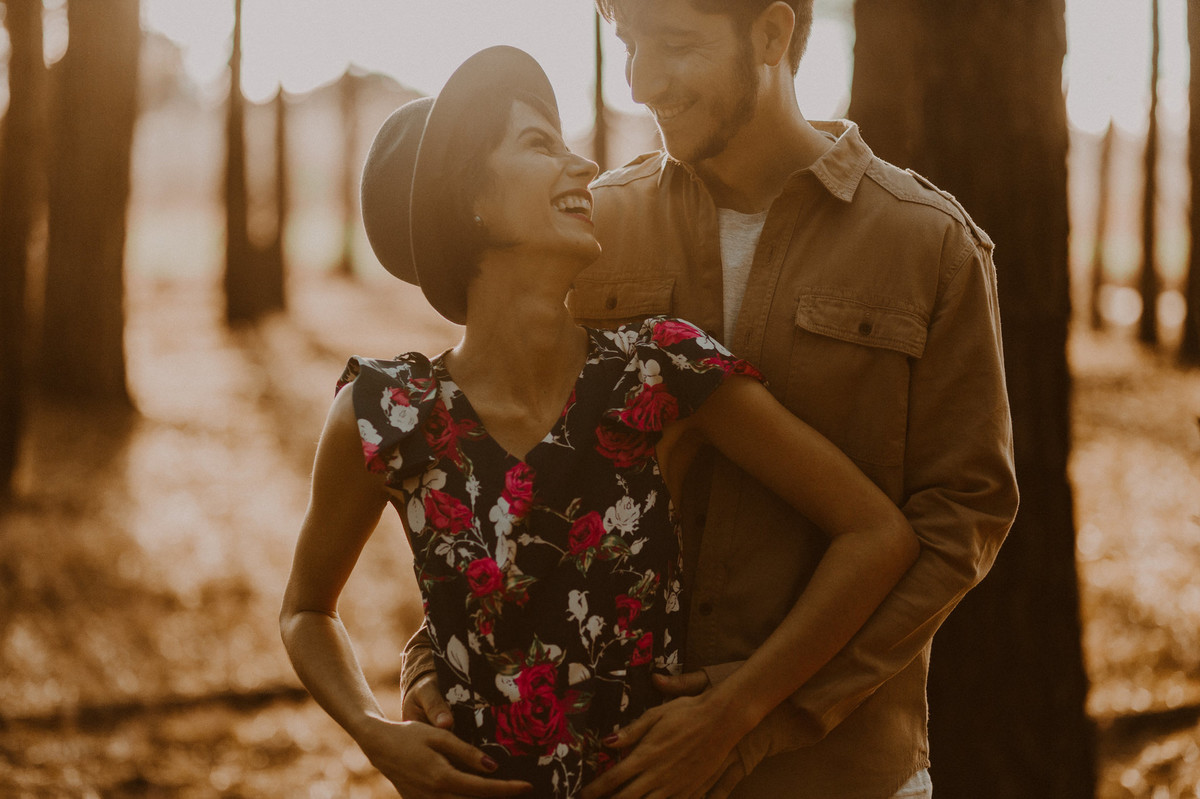 Casal abraçado sorrindo em floresta de pinheiros em Brasília. Foto feita pelo fotógrafo de casamento Gabriel Pelaquim.